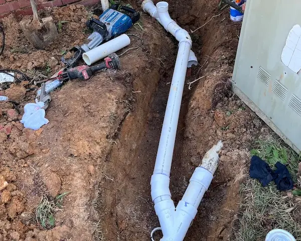 Open trench with a new sewer line and fittings laid in